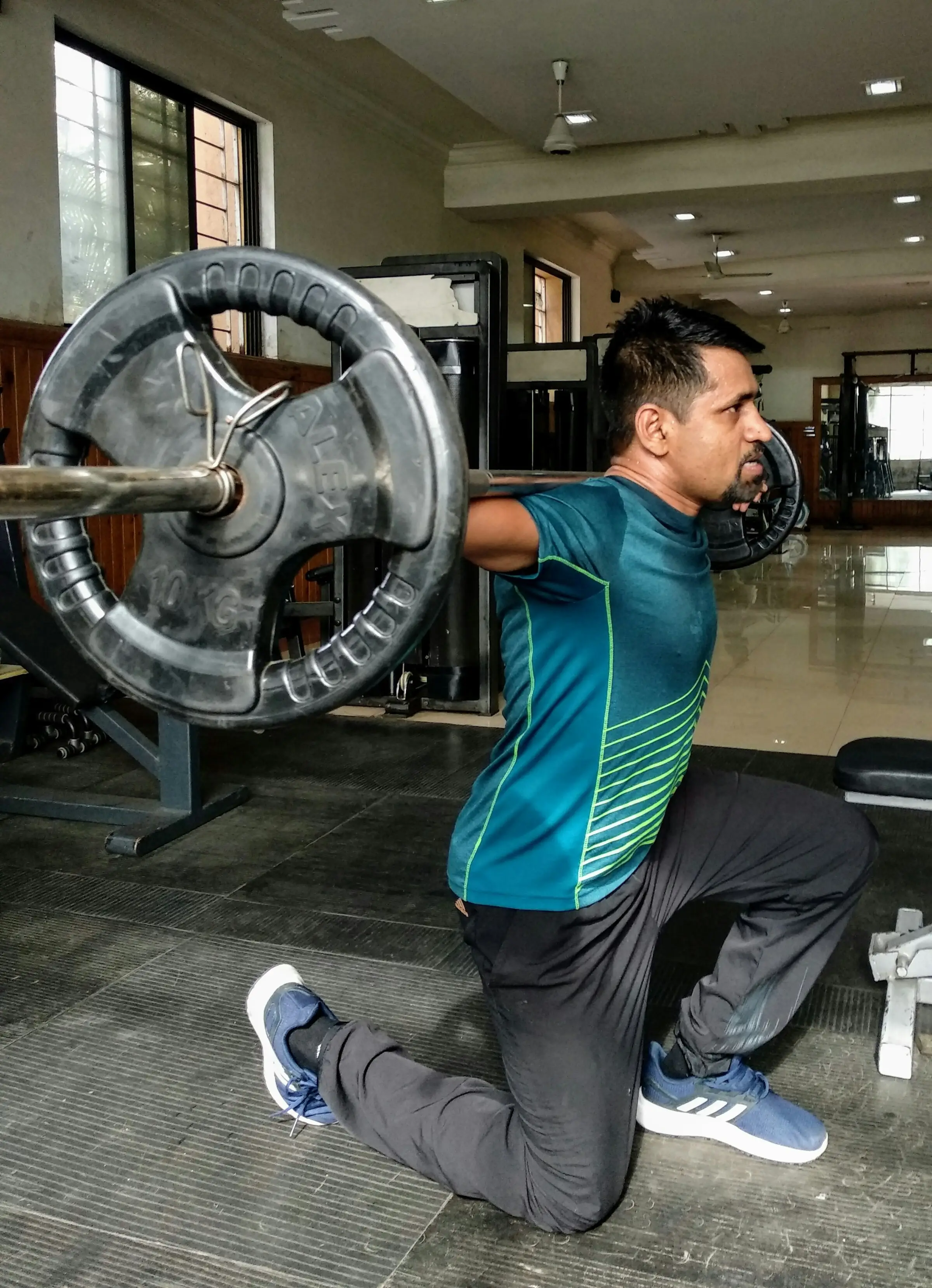 Athlete performing a barbell squat at a gym